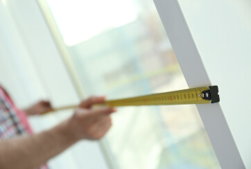 measuring a window's width with measuring tape