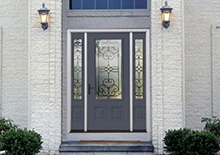 Grey entryway door custom windows framed in stone exterior 