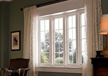4 rectangular white windows with curtains 